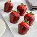 A white plate with chocolate covered strawberries.