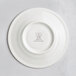 A RAK Porcelain ivory saucer with an embossed crown logo.