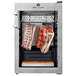 Meat curing cabinet with meat hanging from hooks.