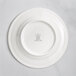 A white RAK Porcelain plate with an embossed crown logo on the rim.