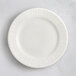 A white RAK Porcelain flat plate with wavy lines on the rim.