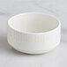 A RAK Porcelain Leon ivory porcelain bowl with wavy lines on a white surface.