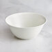 A white RAK Porcelain salad bowl with a curved design on a marble surface.