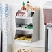A ServSense stainless steel countertop / wall mount condiment organizer with condiments on it.