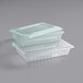 A green Carlisle clear plastic food storage box with lid and colander.
