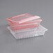 A red Carlisle plastic food storage box with a lid on top of a clear plastic food storage box.