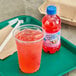 A plastic cup with Hawaiian Punch Lemon Berry Squeeze next to a bottle of Hawaiian Punch Lemon Berry Squeeze.