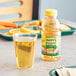 A glass of Mott's apple juice next to a bottle of apple juice on a table.