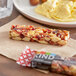 A KIND Cranberry Almond bar with nuts and fruit on a surface.