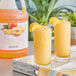 A pitcher of Narvon Peach Slushy made with Narvon Peach Slushy Concentrate on a table in a smoothie shop.