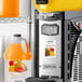 A machine with a container of Narvon Mango Slushy concentrate.