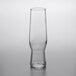 A clear Libbey flute glass with a small amount of liquid in it.