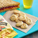 Musselman's Apple Sauce Oatmeal Cookies on a blue tray with a sandwich and drink.