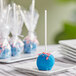 A blue Chalet Desserts cake pop on a white plate.