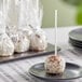 A Chalet Desserts Cookies and Cream cake pop on a stick.
