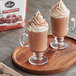 Two glass mugs of Land O Lakes Cocoa Classics Chocolate Supreme hot chocolate with whipped cream on top.