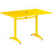A yellow Lancaster Table & Seating outdoor table with a metal base.