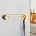 A yellow AvaTemp digital probe thermometer with a black cord attached to a white surface.