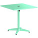 A sea foam green Lancaster Table & Seating outdoor table with a black round top.