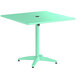 A sea foam green Lancaster Table & Seating outdoor table with a black round top.