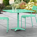 A Lancaster Table & Seating sea foam green table with chairs on a patio.