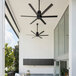 A Big Ass Fans black aluminum outdoor ceiling fan on a patio with a table.