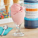 A glass of pink ice cream next to a bottle of LorAnn Bubble Gum Flavor Fountain syrup.