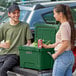 A man and woman standing next to a Hunter Green CaterGator cooler.