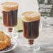 A table with two glasses of Crown Beverages Organic French Roast coffee and a croissant.