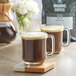 Two mugs of Crown Beverages Organic French Roast coffee on a wooden table.
