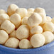 A bowl of Cinnamon Bun Cookie Dough Bites Topping, white balls.