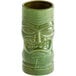 A close-up of a Libbey green ceramic tiki tumbler with a face carved into it.