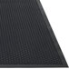 A close up of a black Guardian Clean Step rubber entrance mat with holes.