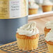 A close up of a vanilla bean cupcake with white frosting.