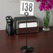 An American Metalcraft black swirl base table number holder with a number in it.