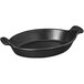 A black oval Chasseur enameled cast iron pan with handles.