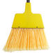 A yellow Choice 10" Economy Angled Broom with long bristles.