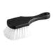 A close-up of a black Choice polypropylene utility and pot scrub brush with white bristles.