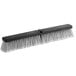 A close-up of a black and white Lavex push broom head with flagged bristles.