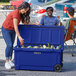 A woman and man putting drinks into a navy blue CaterGator outdoor cooler.