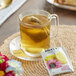 A glass mug of Bigelow Benefits Lemon and Echinacea Herbal Tea with a tea bag in it.