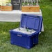 A CaterGator navy outdoor cooler with ice and bottles inside.
