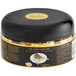 A black container with a yellow label and gold foil with the words "24K Edible Gold Flakes" on a white plate.