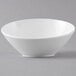A white Get melamine slanted bowl on a gray surface.
