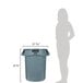 A woman standing next to a large grey Rubbermaid trash can.
