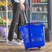 A person pushing a Regency Blue plastic shopping basket with wheels.