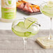 A glass of Top Hat Provisions Sugar-Free Margarita Mix with a lime wedge on the rim.