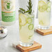 A glass of Top Hat Provisions Sun Goddess Cucumber Lemonade with lemons and cucumbers.