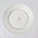 A white RAK Porcelain flat plate with an embossed design on the rim.
