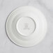 A RAK Porcelain ivory deep plate with an embossed crown logo on the wide rim.